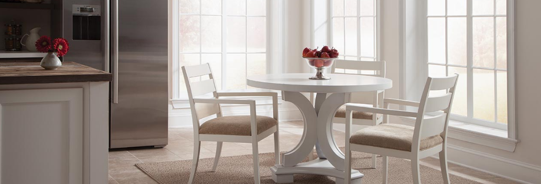 A beige area rug on an lvt kitchen floor adds warmth and softness beneath a kitchen table.